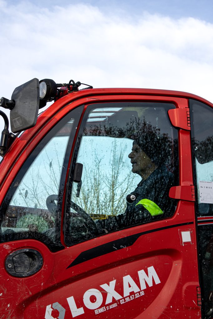 technicien chargeant un véhicule sur son camion.