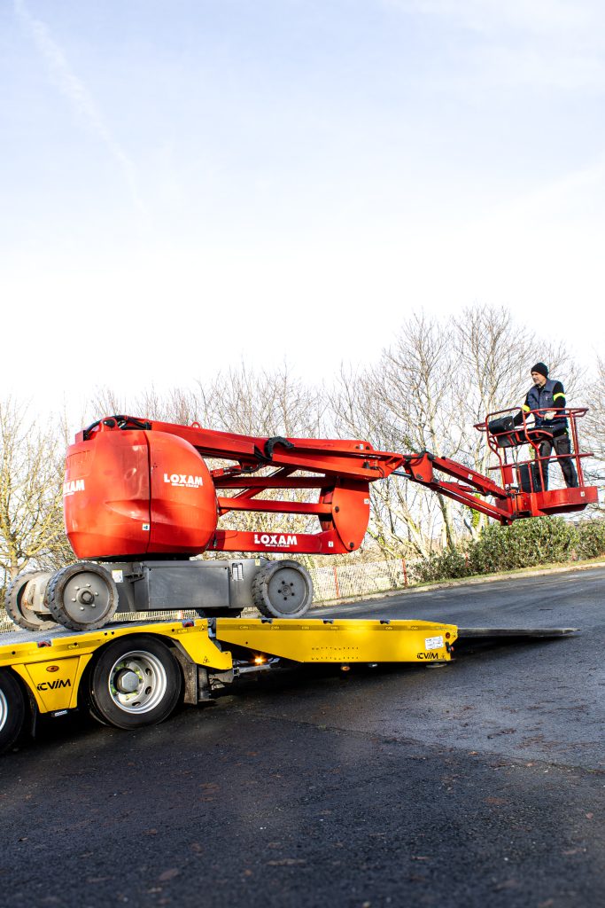 Technicien entrain d'effectuer le chargement d'un véhicule de chantier.