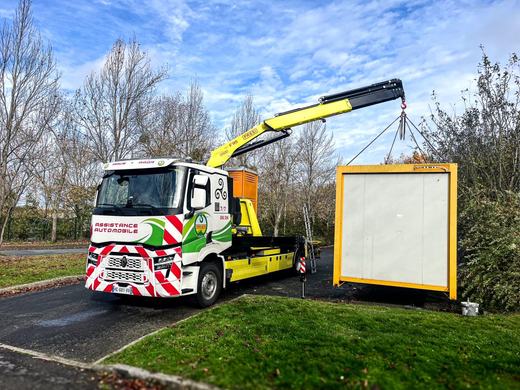 camion de grutage soulevant un contenant. 