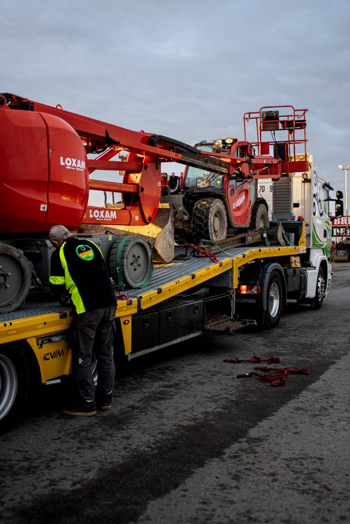 technicien déchargeant les engins de chantier.